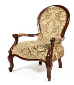 A Victorian mahogany framed upholstered spoon back armchair, with scroll carved arms,