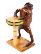 A taxidermy model of a toad playing the drums,
