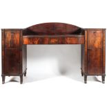 An early 19th century mahogany sideboard, the D-shaped top with reeded front and two frieze drawers,