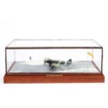 A glass cased scratch built diorama of a landing spitfire in a snowy scene