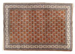 A Persian style wool floor rug, burnt orange ground with geometric borders,