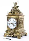 A French cast gilt brass mantle clock. White enamel face with Roman numeral markers.