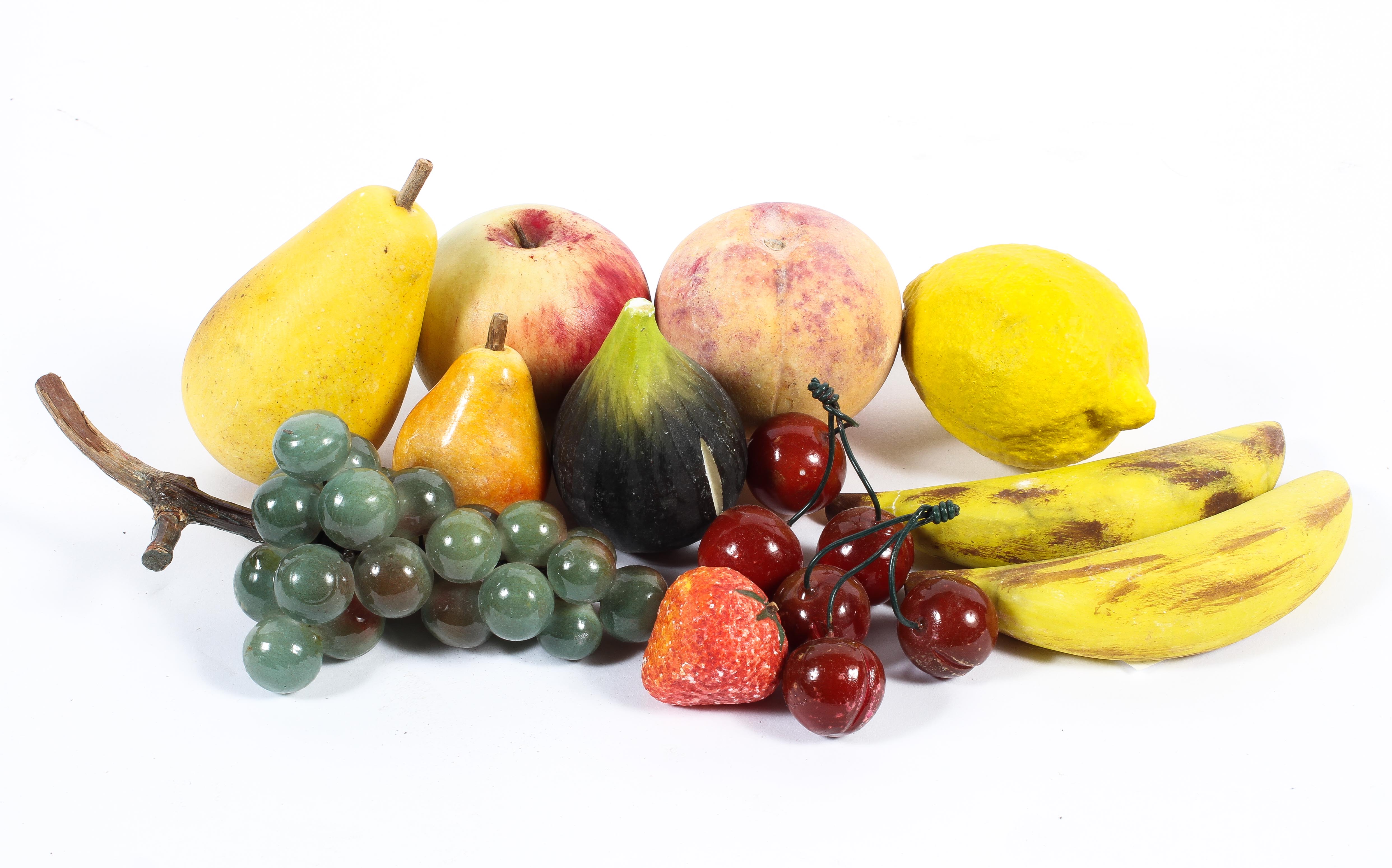 A collection of contemporary stone and painted resin fruit, including a bunch of grapes, cherries,