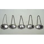 A collection of five silver decanter labels, comprising; Port, Scotch, Rum, Cognac and Sherry,