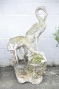 A large 20th century marble statue of two cranes standing on a rock,