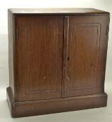 An Art Deco mahogany table top cabinet, the twin doors opening to reveal three shelves,