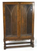 A 20th century display cabinet, the glazed double doors opening to reveal two adjustable shelves,