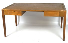 A mid-century oak two drawer desk, stapled brown insert to the top,