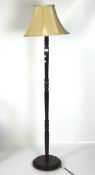 A 20th century electric floor lamp, raised on a turned column and supported on a stepped base,