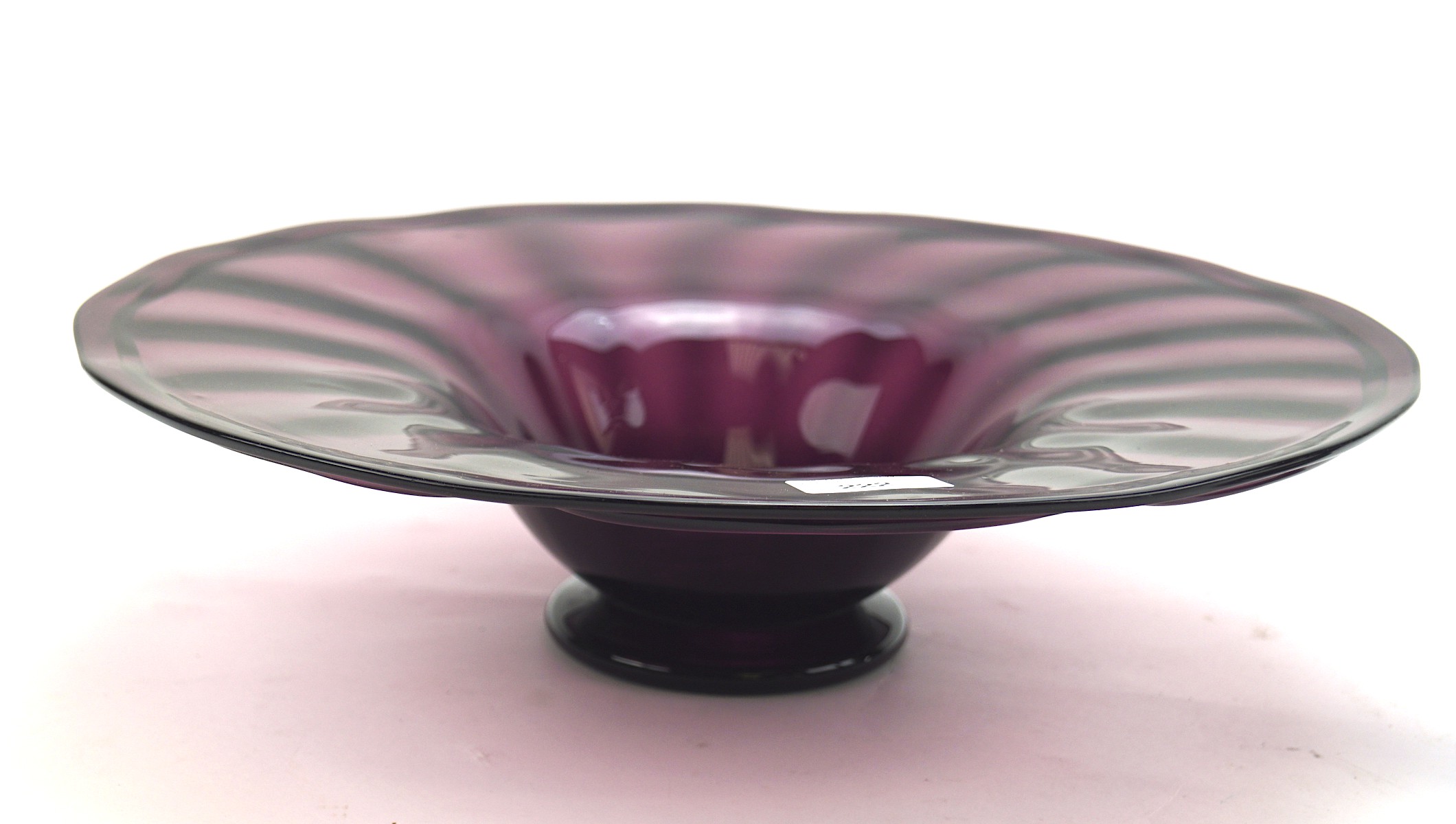 A large amethyst glass bowl, of circular form with a fluted rim,