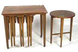 A mid-century teak veneer coffee table on casters with four folding round stools