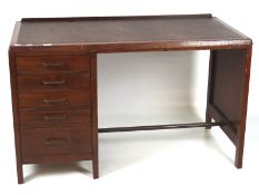 A mid century stained oak desk, the kneehole space flanked by five drawers, leatherette top,