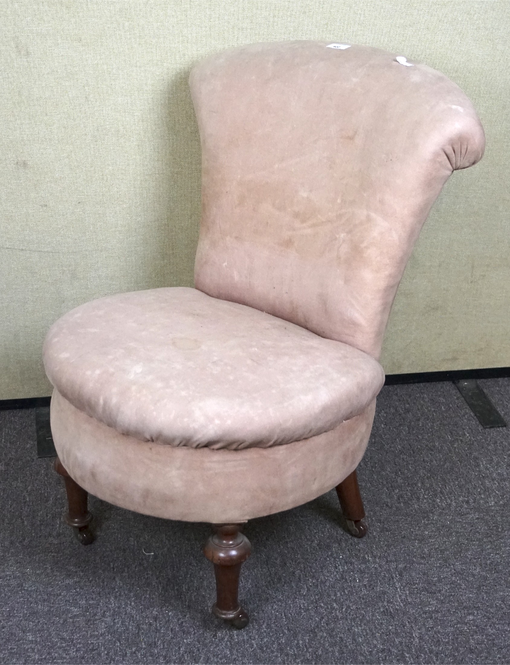 A late 19th century nursing chair, the wooden frame with turned feet and upholstered in pink velvet,