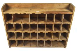 A vintage wooden pigeon hole unit with 32 holes divided by removable uprights, (three missing),