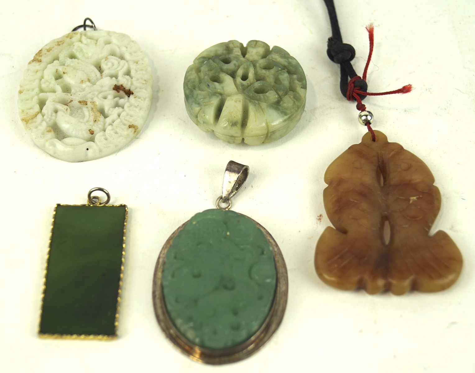 Five Oriental Jade and hardstone pendants, including one carved in the form of two Fish,