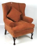 A Multi york armchair, upholstered in red fabric with cabriole legs to the front,