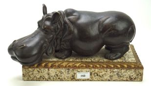 A contemporary spelter sculpture of a hippo, mounted on a marble plinth with gilt details,