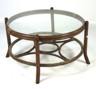 A contemporary bamboo framed table, of circular form, a glass panel to the top,