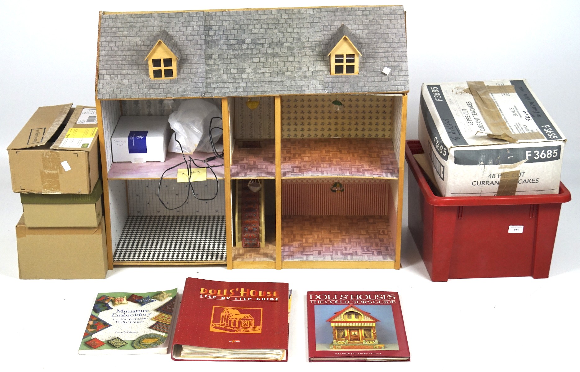 A vintage dolls house with a selection of dolls house furniture and books,
