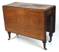 A late 19th century mahogany drop leaf table, raised upon turned supports on original castors,