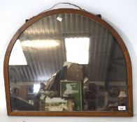 A wooden framed wall mirror, shaped with a domed top