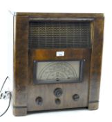 A vintage radio, having a speaker to the front and four dials, in a wooden case,