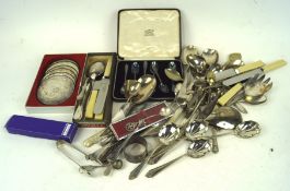 A collection of silver plated flatware, including spoons, knives, a napkin ring,