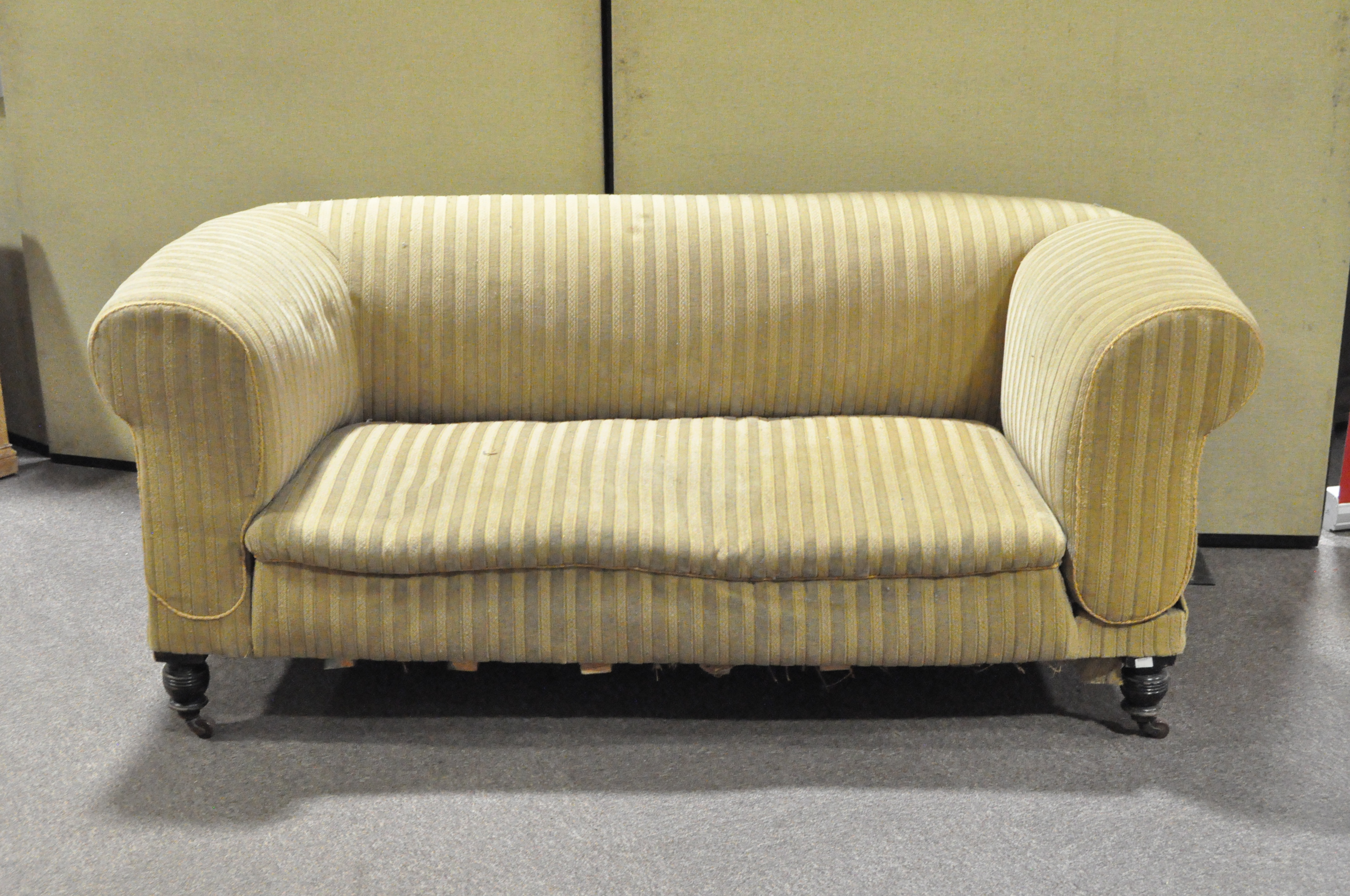 A Victorian two seater green striped sofa on turned supports and casters, height circa 75cm,