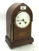 An early 20th century arched mahogany mantle clock with inlaid details to the case,