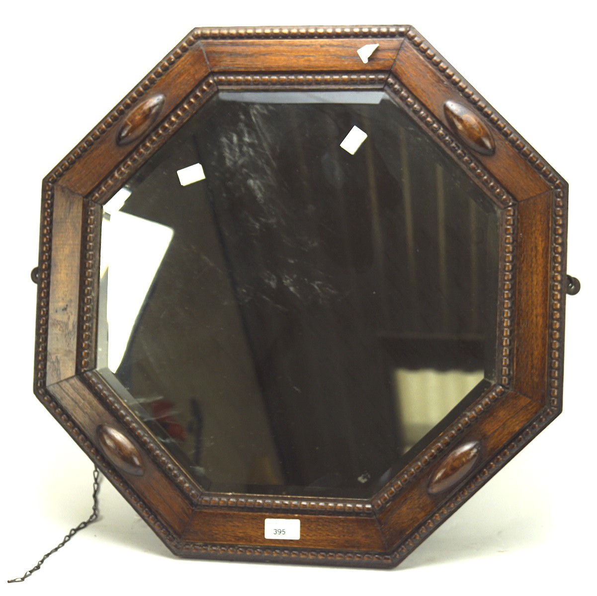 An early 20th century oak framed bevelled edge mirror, of octagonal form,