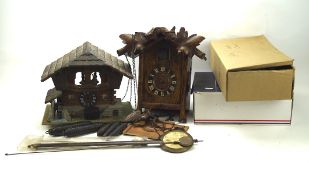 A collection of cuckoo clocks and related parts, to include two wooden casings,