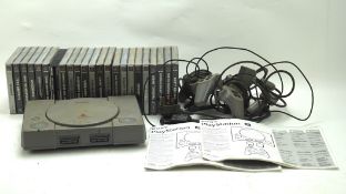 A Playstation One console with two related controllers and a selection of games, including Worms,