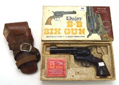 A six shot BB gun by Daisy in the original box, and a vintage leather gun holster,