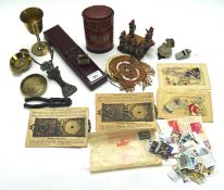 An assortment of collectables, including a brass goblet, embroidered postcards,