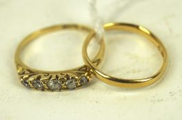 A 22ct gold wedding band and an 18ct gold five stone diamond ring