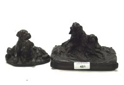 Two resin sculptures of dogs, one featuring two puppies,