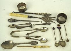 An assortment of silver and silver plate, including a pair of sugar tongs, two napkin rings,