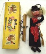 A Pelham puppet of a witch carrying a broom,