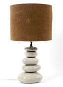 A contemporary table lamp with glazed pebble formed base, with pierced brown shade,