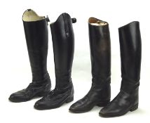 Two vintage pairs of leather riding boots, with one pair containing wooden boot trees,