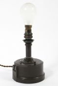 An early 20th century wind-up Bakelite table lamp, with central dial and on/off switch,