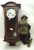 Two 20th century wall clocks, one being adorned with a finial depicting the God Atlas,