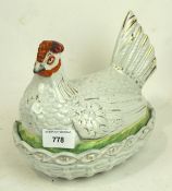 An early 20th century dish modelled as a hen sitting on a nest, likely Staffordshire,