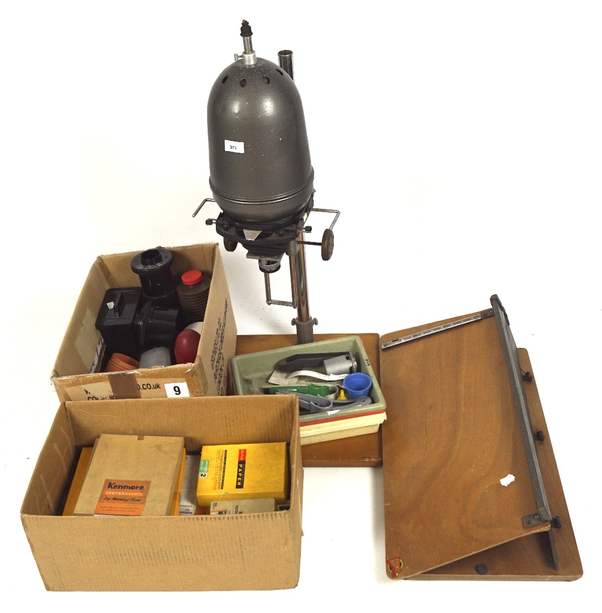 A vintage photographic darkroom enlarger and an assortment of related equipment with guillotine