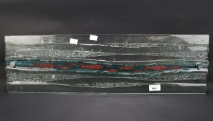 A contemporary rectangular piece of artistic glass, modelled as fish swimming through water,