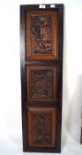 A set of three carved oak panels mounted in frame, each depicting a tavern scene,