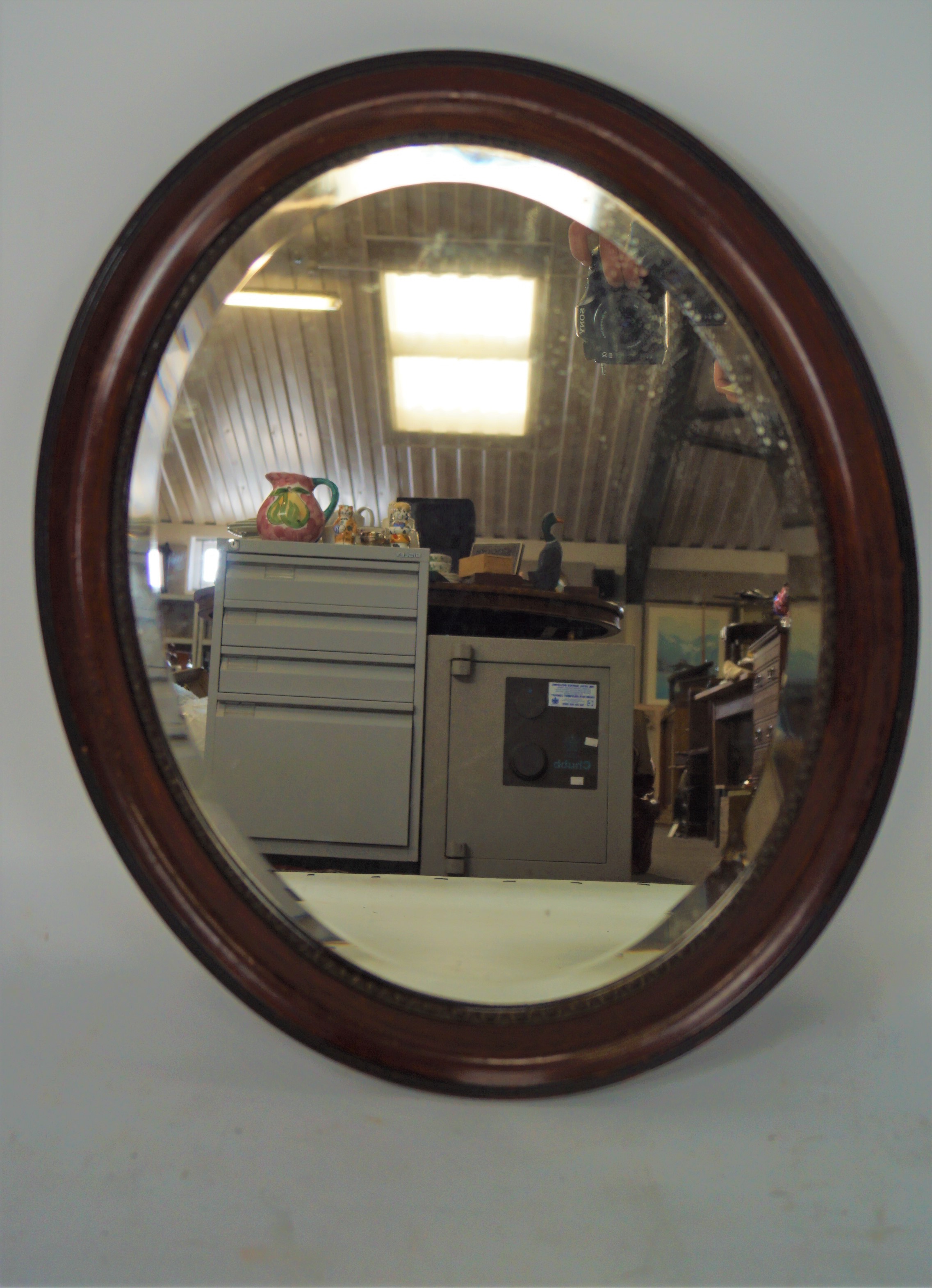 A late 19th/early 20th century oval bevelled mirror with moulded frame,