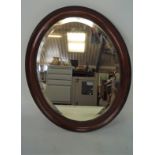 A late 19th/early 20th century oval bevelled mirror with moulded frame,