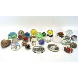 A collection of paperweights, including glass, plastic and wooden examples,