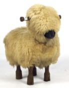 A contemporary novelty sheepskin covered footstool/childs seat, in the form of a sheep,